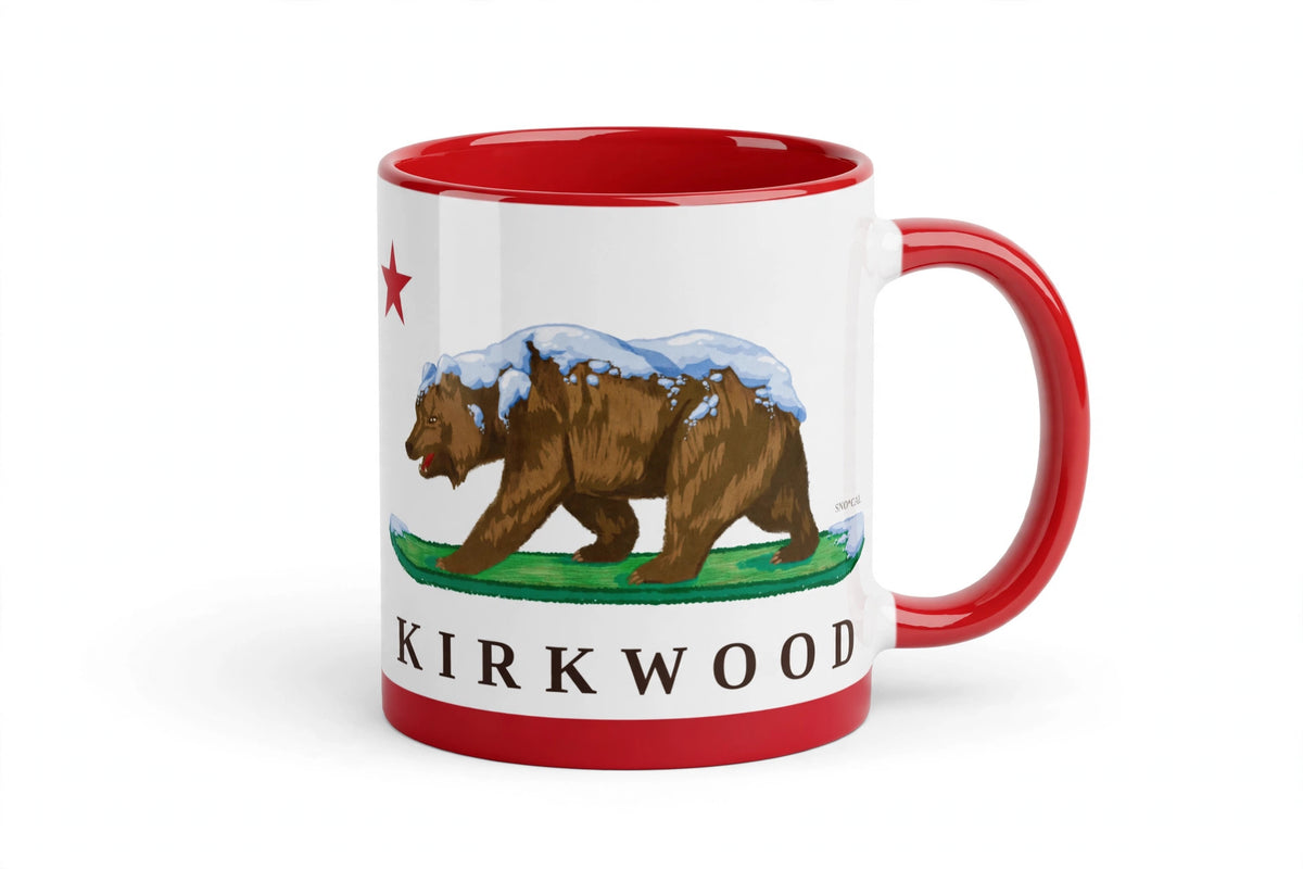 White ceramic mug with red rim handle and inside with Kirkwood CA flag design, grizzly bear walking on a snowboard, angled view